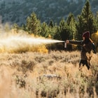 Full image of the Bear and Mountain Lion Spray being sprayed from a distance.