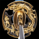 Close view of detailed metal ornate dragon tsuba handguard and brass habuki
