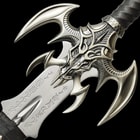Detailed view of the bat wing style guard with leather wrapped handle accented with rune-like characters. 