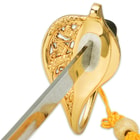 Zoomed view of the brass plated guard with floral design and heavy cord tassel on handle. 