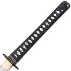The white genuine ray skin handle is wrapped with black cord and has a menuki. 