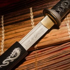 Katana sword encased in wooden dragan saya with peeking of steel blade showcasing laser etchings in Japanese characters
