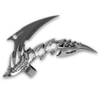 Side view of the claw knife with ornate design and talon-shaped blade. 