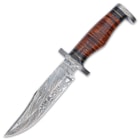 The knife has a 7” Damascus steel clip point blade, which extends from a hefty, Damascus steel handguard