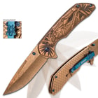 The knife is shown in action with its assisted opening mechanism and flipper and blue pocket clip with skull samurai medallion.