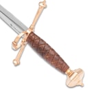 A detailed look at the crosshatching on the Honshu Italian Dagger’s wooden handle with gold-colored rounded pommel and crossguard with ring.