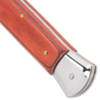 Detailed view of the wooden handle with stainless steel push button and brass liners.