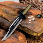 Angled view of the 8 1/2” stainless steel blade next to the mini survival kit that can be found within the knife’s handle.
