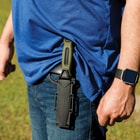 The fixed blade knife in its sheath clipped onto a pocket