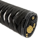 The hardwood handle is wrapped in faux rayskin and black cord and has an intricately detailed metal alloy tsuba

