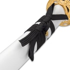 Zoomed view of black cord wrapped around shaft of white lacquered scabbard
