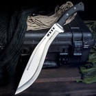 The Boshin Kukri is shown with its curved blade and TPR handle leaned against tactical gear.