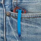 The knife is shown clipped into a denim pocket with the metallic blue pocket clip showing.