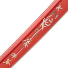 The 41” katana slides into a red lacquered wooden scabbard, accented with faux mother of pearl inlays and black cord-wrap