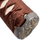 The pommel has a bamboo leaf design just above the brown cord wrapped handle. 