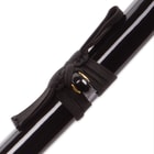 "Zoomed display of solid black lacquer finished hardwood scabbard with black nylon cord wrapped around brass knob"
