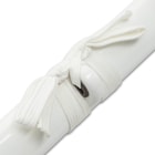 Japanese sword with black damascus steel and white nylon cord wrapped faux rayskin handle laying next to white scabbard
