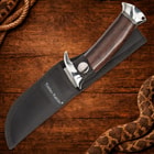 Knife in black sheath with wooden handle on wooden background