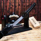 Katana on stand with mask and wooden box in background