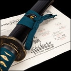 Katana with tsuka wrapped in a teal cord and tea dyed rayskin encased in black scabbard with a teal cord around a brass knob
