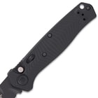 Upclose view displaying the milled chevron pattern G10 matte black andle scales with a lanyard hole and automatic open button.

