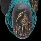 It has an antiqued brass, pommel with an intricately detailed standing crane and river design