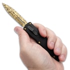 Close up image of Midas Touch OTF held in hand.
