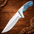 Knife with blue handle on wooden background