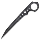 "Undercover" stinger knife being held in front of a black knife sheath attached to a military-style boot.
