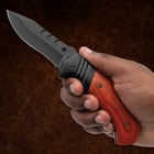 Hand holding a knife with a wooden handle
