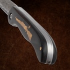 Close-up of knife handle with rifle inlay and blade edge