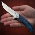 Open pocket knife with an inscription of "Honsu" on the blade and a tie-dye style blue and black handle. 
