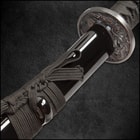 Close shot of katana handle with genuine rayskin wrapped in black cord showcasing brass menuki and wooden mekugi
