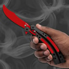 Hand holding a red and black butterfly knife