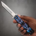 Hand holding butterfly knife with dragon design