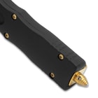 Close up angled image of OTF knife handle and glass breaker.