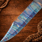 Close-up of colorful knife blade on wooden background