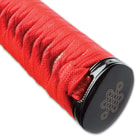 The hardwood handle is wrapped in faux rayskin and red cord and has an intricately detailed metal alloy tsuba