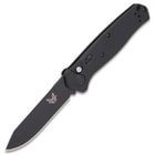 Open benchmade mediator automatic knife with non-reflective black steel blade and G10 handle.
