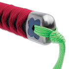 The wooden handle is wrapped in black faux rayskin and red cord with a black cord and bead tassel in the pommel