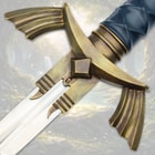 Detailed view of sword's brass handguard and blade in a forest