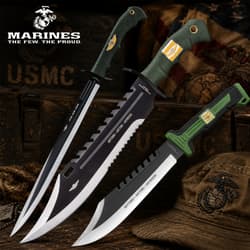 Three tactical knives with USMC branding on a wooden background