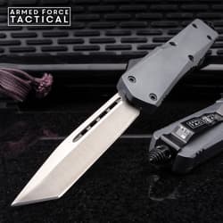 Tactical knife with a sharp blade on a textured surface