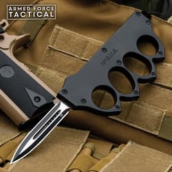 Tactical knife with knuckle grip on military gear