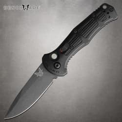 Black folding knife with textured handle on gray background