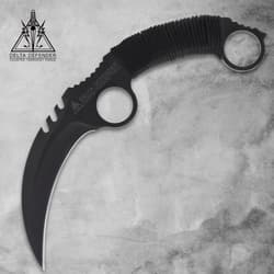 Black karambit knife with cord-wrapped handle on gray background