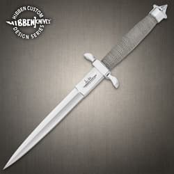 Satin finish dagger knife with a wire wrapped hilt and hefty handguard inscribed with "Gil Hibben" on a background of black stone.