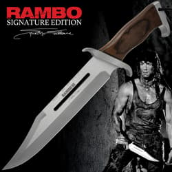 Rambo 3 Signature Edition Knife Stallone.A clip point with a sharp tapered tip blade engraved with "Rambo III" and a signature handle made of dark wood with visible grain patterns.