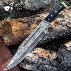 Damascus steel knife on wood logs with Timber Rattler logo