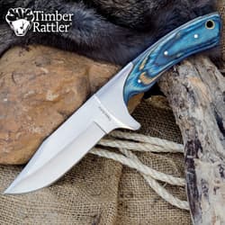 Knife with blue handle on rocks and fur background